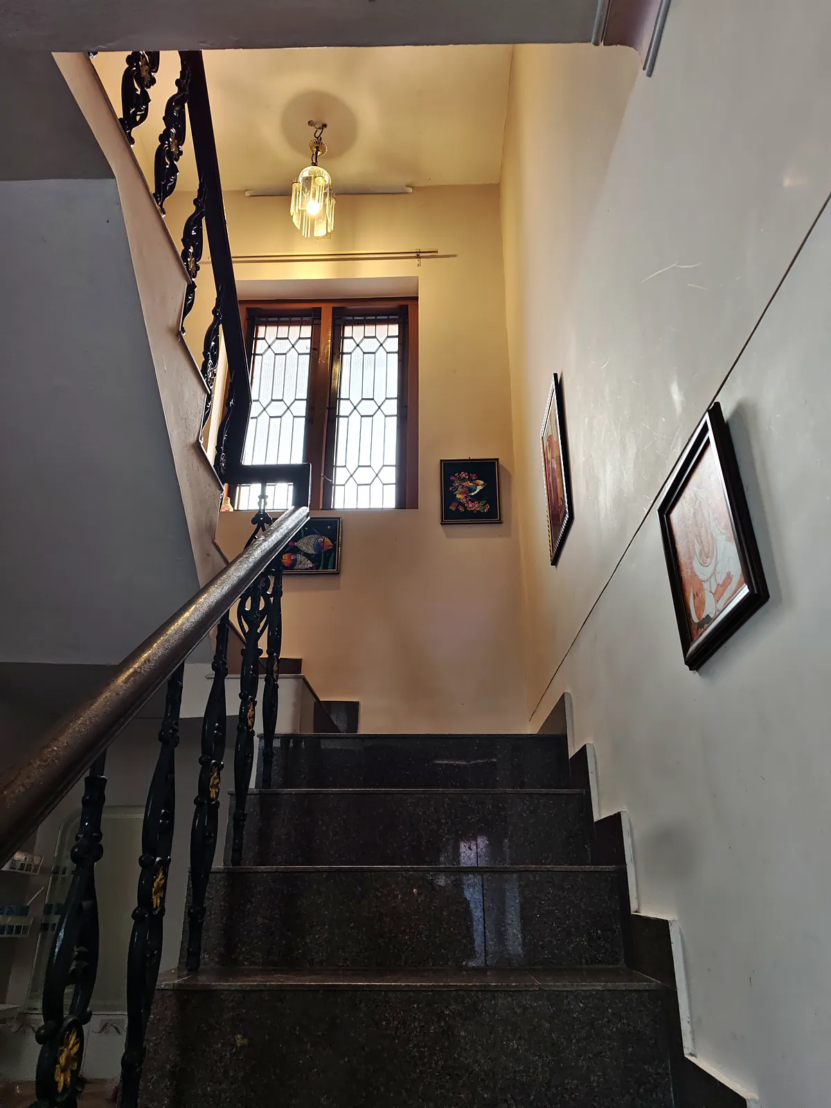 Staircase with an ornamental iron balustrade leading to the bedrooms
